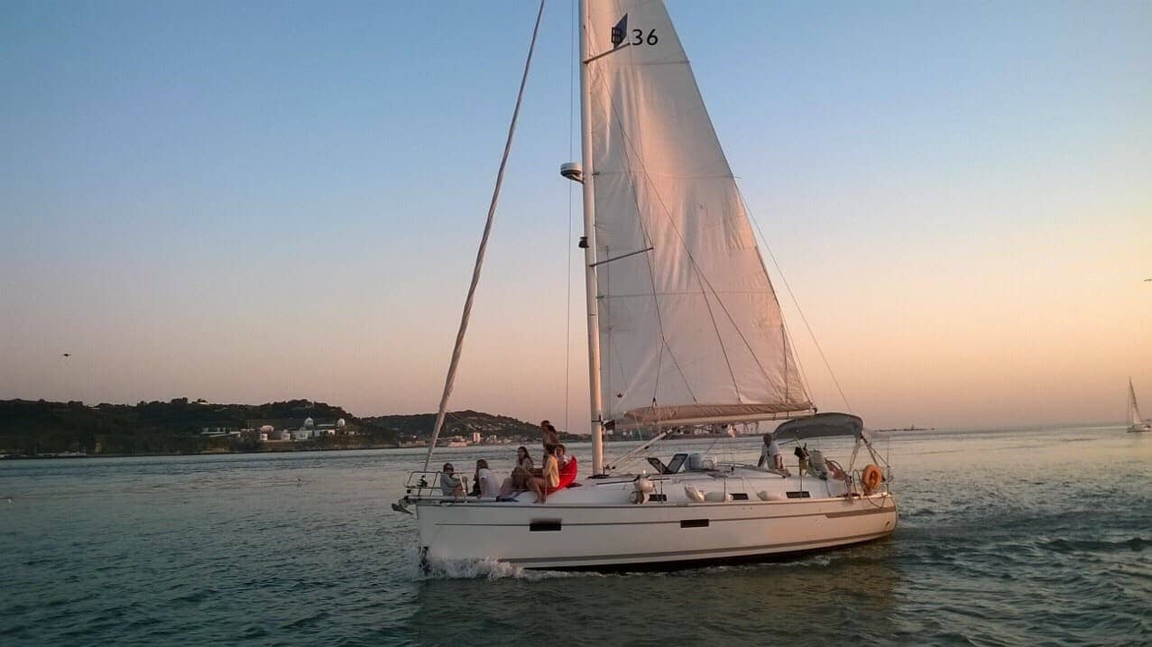 Boat trip on the Tagus River in Lisbon by sailboat or catamaran during sunset