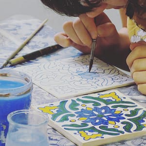 Painting a tile during an azulejos workshop in Lisbon