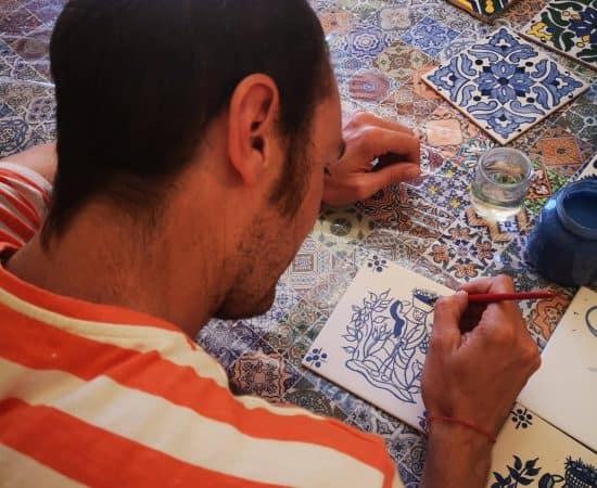 Painting a tile during an azulejos workshop in Lisbon