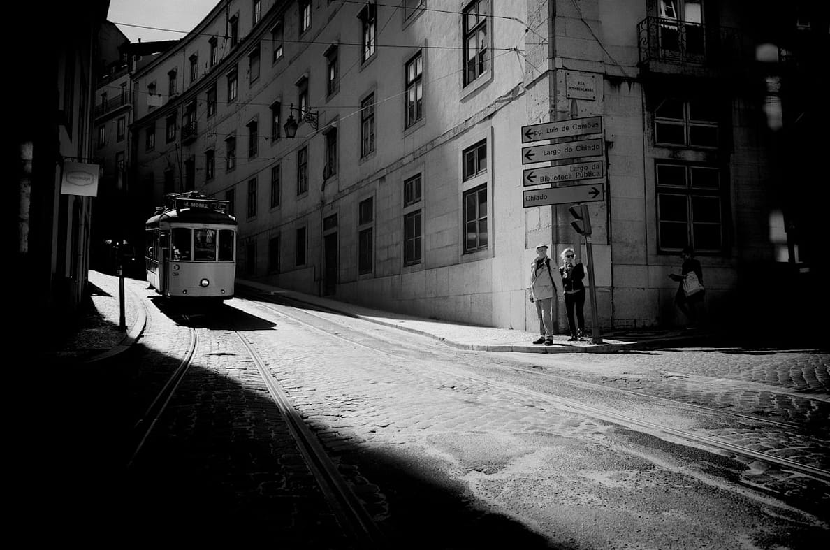 Iconic yellow tram 28 in a Lisbon street with historic buildings