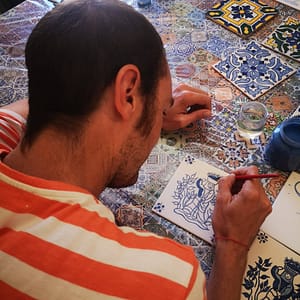 Painting a tile during an azulejos workshop in Lisbon